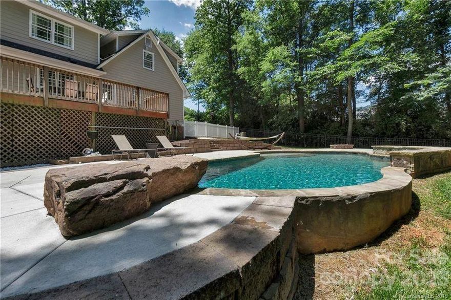 Desirable neighborhood with no HOA, central to Charlotte with wonderful schools. Presently a profitable AirBnB: owners selling only to relocate rental portfolio to Florida. A wonderful rental or amazing house to live in. 5 Bedroom house with dining room currently used as converted to 6th bunk-bed room for optimized STR rental. Beautiful diving pool with waterfall and impressive hot tub overlook a private lot and forest behind house. Various updates and maintenance include remodeled kitchen with 42" cabinets, granite and butcher-block Kitchen Island. Replaced well pump in 2023. Nice, open layout has two stairs to top floor. Large walk-in closet for primary. Home is sold furnished minus the dining room table and chairs. Home needs paint touch up and carpet replacement in some areas. Airbnb guests are rough on properties.