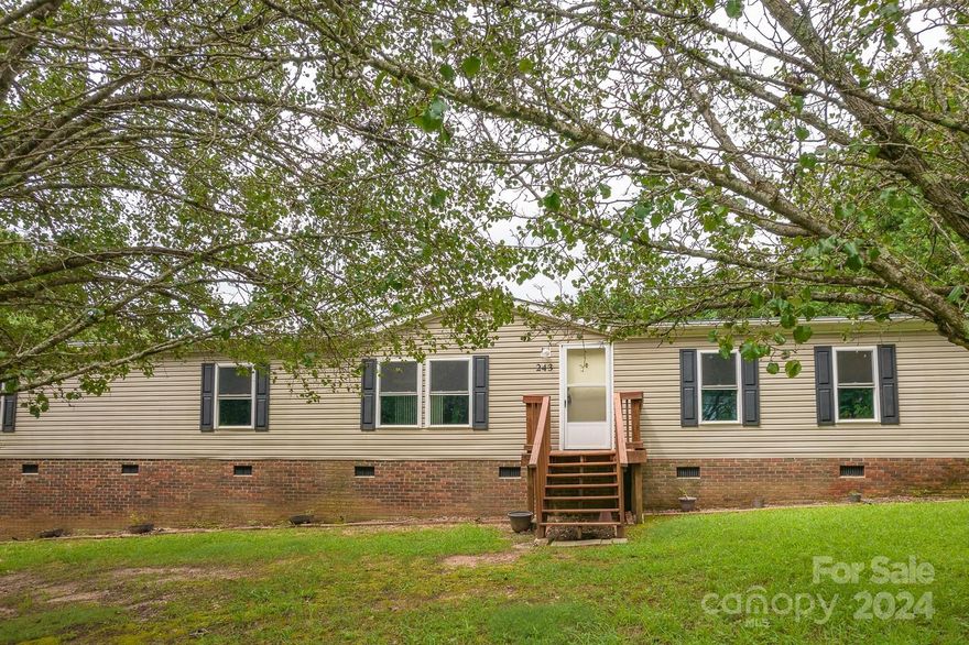 Look no further, finally a 4BR 2BA home that is affordable!  This 2052 hsf Manufactured home is nestled in the quiet community of Featherstone. Very nice .70 acre corner lot, with an expansive deck that leads to an above ground pool.  Lot's of space for everyone with a livingroom and a family room with nice stone FP. Huge Primary BR and en suite BA has soaking tub & sep shower. Some new flooring in Primary BR and Laundry/Hallway. Close to schools, convenient to major highways, in Western Iredell County. No City Taxes.
