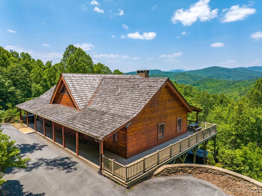 Presenting 'The Lodge at Timber Rock', a 4,000+ SF rustic, luxury retreat, just 10 minutes from Blowing Rock. This year-round accessible, private estate comes fully furnished w/ a proven rental history. Featuring an open-concept great room,2 main level master suites,2 additional en-suite bedrooms, dual living rooms, & 3 stacked stone fireplaces. Enjoy 1,700SF of wrap-around decks showcasing captivating Blue Ridge Mountain views. Graceful interiors feature wood floors, stainless appliances, granite countertops, & ceramic tile. The open kitchen & formal dining area make it easy to entertain. Situated in the gated Timber Rock community, residents have access to a grilling pavilion w/ fireplace & Yadkin River. Additional amenities include: 2-car garage, hot tub, lower living area w/ a wet bar, half-baths on each level, large closets, Trex decking, & custom stained concrete floors. The Lodge blends solid rental income history w/ exceptional mountain living, all just minutes to Blowing Rock!