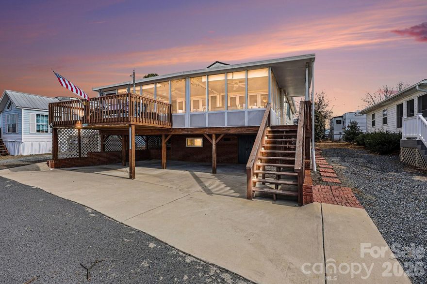 Nestled within the waterfront community of Badin Shores Resort, this 2-bedroom, 2-bath modular home offers the epitome of lakeside living. Start your days with serene mornings on the expansive screen porch and wind down watching breathtaking sunsets from the open deck overlooking a winter view of Badin Lake. The open-concept kitchen and living room provide a welcoming space for gatherings, while the convenient hallway laundry area adds practicality to daily living. Your furry companions will love the ease of the ramp leading to the fenced-in yard area. Below, discover an incredible storage area with over 5 feet of height, perfect for storage or a hobby room. Take full advantage of resort amenities including a swimming pool, waterfront boardwalk, fishing pier, fishing pond, putt-putt, basketball courts, picnic pavilions, playgrounds, horseshoe pits, & more, ensuring endless opportunities for recreation and relaxation. Experience the ultimate lakeside lifestyle in this inviting abode.