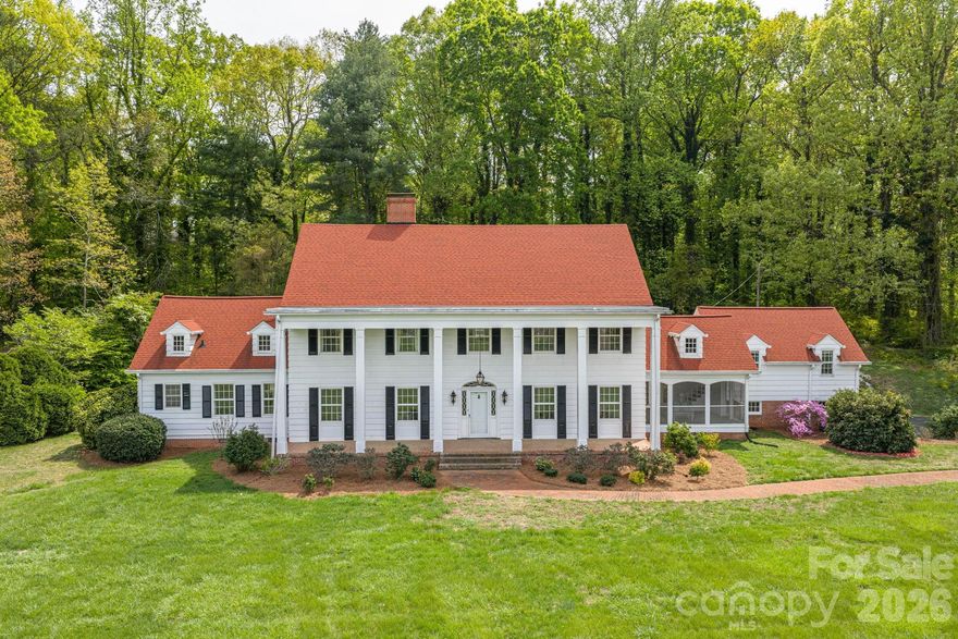 Some locals recognize this remarkable property as part of the historic Lithia Springs area of Lincolnton. This stunning colonial estate offers 6 bedrooms, 5.5 bathrooms, and sits on 10 acres of beautifully maintained land in the desirable Lincolnton Country Club area, just a short drive to Charlotte and Hickory. Situated across from the original site of the historic Lithia Inn—once known for its natural mineral springs and peaceful countryside setting—this property is part of a unique and storied corridor with deep local roots. While the original inn is no longer present, the legacy of the area continues to add character and charm.
The home features nearly 6,000 square feet of living space with a thoughtfully designed layout, oversized rooms, and hardwood floors throughout. The updated kitchen showcases wormy chestnut cabinetry, exposed beams, and granite countertops, with both formal living and dining rooms. A spacious library-style family room, pool room, and third-floor recreation space provide ample room for entertaining and everyday living.
The primary suite offers dual bathrooms with a sitting area, creating a private retreat. Additional highlights include upgraded lighting, fresh paint, a large screened porch, and multiple gathering spaces throughout.
A separate in-law suite offers approximately 2 bedrooms and 1 bath with a classic clawfoot tub—ideal for guests or multi-generational living. The basement, unfinished attic, and oversized two-car garage provide abundant storage. Exterior features include solid cypress siding and expansive grounds with endless potential for outdoor living, events, or a future pool. This exceptional estate combines privacy, space, and history—offering a rare opportunity to own a truly special property in one of Lincolnton’s most scenic settings.