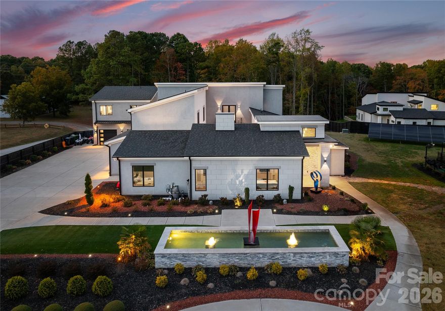 Just minutes from Lake Wylie, this modern masterpiece invites you to experience the perfect harmony of tranquility and entertainment. Set on 3.27 acres, this estate offers a private resort atmosphere designed for those who want to live without compromise.

Step inside to discover 5 exquisite bedrooms, 5 full baths, and 2 half baths, anchored by expansive living spaces that blend style and function. A custom theatre with wet bar, office loft, and game room make this home ideal for both work and play, while a 380-gallon saltwater aquarium adds a captivating focal point to the main level.
Outdoors, every amenity has been curated for indulgence and connection. Two sparkling pools, a hot tub, and two distinct BBQ entertainment areas—including one with air conditioning, TV, and a pizza oven—create the ultimate setting for gatherings. A commercial-grade gym with massage chair and sauna transforms daily wellness into a luxury experience.

Family-friendly features include a gated playground with dual trampolines, and practicality meets passion with a 5-car garage and a 15x32 powered storage building. The comprehensive security system ensures peace of mind, while the guest house provides the flexibility of hosting extended family or generating Airbnb income.
Whether you’re seeking peaceful seclusion or an entertainer’s dream, 15700 Youngblood Rd delivers both in stunning fashion.