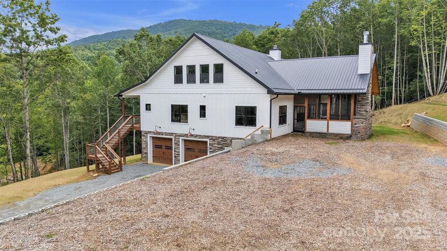 A rare opportunity to own a 2025 custom-built mountain retreat on nearly 13 acres of serene, unrestricted land—just 10 minutes to the Jeffersons and 20 to Boone. This over 4,000 sq ft estate offers rustic elegance with a vaulted great room, floor-to-ceiling stone fireplace, luxury hardwood flooring, and a chef’s kitchen featuring quartz counters, large island, walk-in pantry, and high-end finishes throughout. The main level includes a luxurious primary suite, two spacious guest bedrooms, two full baths, office space, and laundry room. Upstairs offers a loft, gym area, oversized bedroom, and another full bath. An expansive unfinished basement adds unlimited potential. Enjoy mountain air from the screened porch with a second fireplace, wraparound decks, and a scenic fire pit. Property also includes a fully equipped tiny house plus a detached studio for guests, short-term rentals, or creative space. No HOA, total privacy, abundant wildlife—your dream escape in the NC High Country.