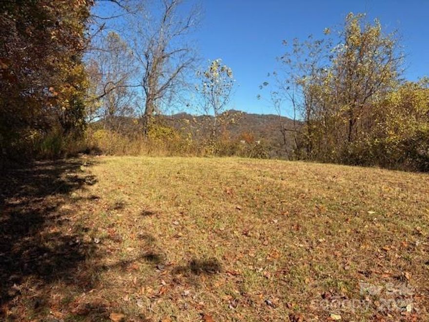 One of the best developments in Haywood County; One of the best lots in this development; One of the best locations!!! This lot has a roughed-in and level housepad; along with a roughed-in driveway. Most of the site work has been done. Step onto this property/homesite to see what makes it special. It offers privacy, year-round mountain views, & a desirable 3,000'+ elevation. Public water is available with a tap fee to Maggie Valley Sanitary district; no need to drill a well. You will be impressed with this neighborhood of above average homes; mostly newer & stylish. The road system in this development is mostly paved; you can reach this property entirely by paved roads. The roads provide moderate grades for comfortable driving & access. Street lights are placed at intervals to enhance night driving. The entrance to this development is gated & attractively landscaped. Suitable for year-round or seasonal use. Close to Purchase Knob, Cataloochee Valley in the Great Smoky Mtns National Park, Maggie Valley, & historic downtown Waynesville. 30-40 minutes to Asheville. Nearby restaurants, shops, entertainment, outdoor activities, & major roadways.