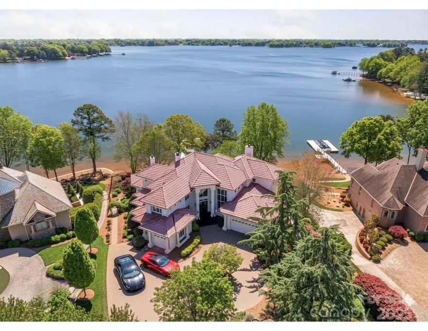 Commanding the shores of Lake Norman, this breathtaking 5BR, 8BA waterfront estate in The Point offers resort-style living for the global buyer seeking privacy, prestige, and panoramic views. Spanning over 7,300 sq ft, the home features soaring ceilings, a grand spiral staircase, chef’s kitchen with fireside lounge, and a lower level designed for entertaining with a theater, wine cellar, full bar, and lounge. Lake-facing suites open to expansive decks for seamless indoor-outdoor living. Outdoors, enjoy a heated pool, spa, fire pit, outdoor kitchen, and covered terrace. A private dock with a boat and two jet ski lifts completes this extraordinary offering. This is timeless Southern elegance with a modern edge—just 40 minutes from Charlotte Douglas International Airport. A rare opportunity to own one of the region’s most exclusive waterfront estates.