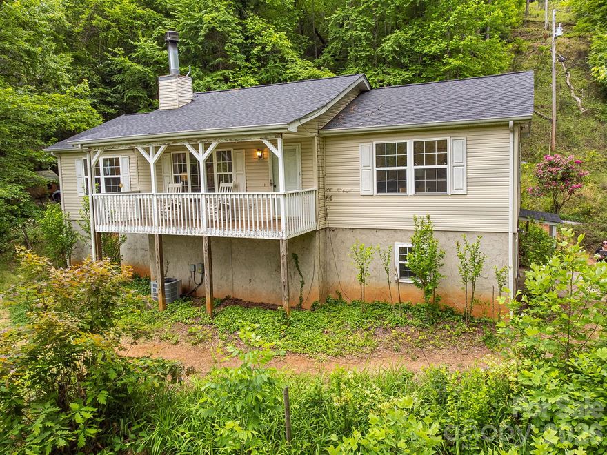 Nestled on 3.37 private acres, this property offers comfortable one-level living just 10 minutes from downtown Sylva and under 20 minutes from Waynesville or Western Carolina University. With almost $100k in recent improvements, this property is a must see and offers excellent value. 

The main floor features a primary owner's suite with a walk-in closet and private bath, along with two additional guest bedrooms and a second full bathroom. A spacious living room, anchored by a cozy wood-burning fireplace, provides the perfect setting for cool mountain evenings.

The home expands into a large basement on the lower level, which includes a private entrance and a full bathroom for added flexibility. There is also a ton of unfinished space in the basement for storage or potential expansion. Outside, the grounds are equipped with a chicken coop and numerous outbuildings suited for hobbies or extensive storage.

A standout feature of the home is the back porch, a peaceful sanctuary that boasts breathtaking views of the Smoky Mountains. Surrounded by forested acreage, this retreat is filled with the sights and songs of native birds, offering a true escape into nature.

The surrounding land is a gardener's dream, showcasing flowering tulip poplars, vibrant flowering trees, and evergreens that provide year-round beauty. The mini-orchard includes a variety of apple, cherry, peach, and plum trees, as well as fig trees and berry bushes in raised beds. 
This location perfectly balances seclusion with accessibility, situated just minutes from the Blue Ridge Parkway and its many hiking trails. Residents can enjoy the quiet of the mountains while remaining close to all that Western North Carolina has to offer.

ATTN BUYERS!!! Motivated Sellers offer $3,500 towards your closing costs/ buy down the rate!