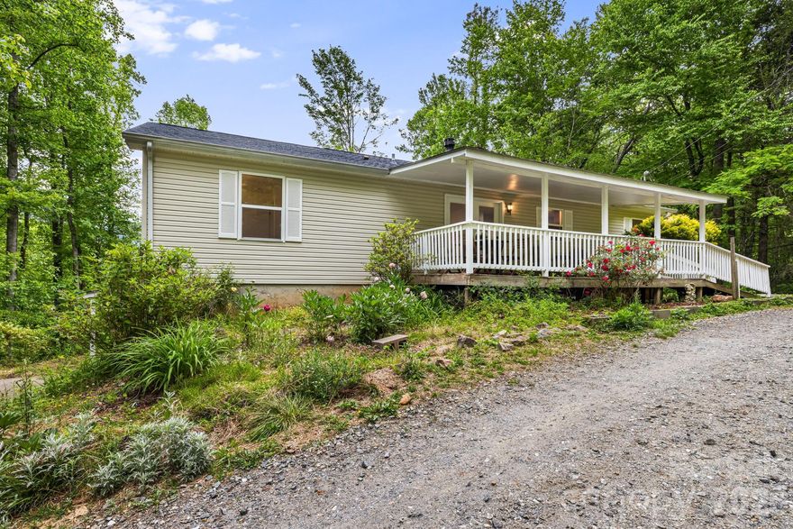 Nestled on 3.37 private acres, this property offers comfortable one-level living just 10 minutes from downtown Sylva and under 20 minutes from Waynesville or Western Carolina University. With almost $100k in recent improvements, this property is a must see and offers excellent value. 

The main floor features a primary owner's suite with a walk-in closet and private bath, along with two additional guest bedrooms and a second full bathroom. A spacious living room, anchored by a cozy wood-burning fireplace, provides the perfect setting for cool mountain evenings.

The home expands into a large basement on the lower level, which includes a private entrance and a full bathroom for added flexibility. There is also a ton of unfinished space in the basement for storage or potential expansion. Outside, the grounds are equipped with a chicken coop and numerous outbuildings suited for hobbies or extensive storage.

A standout feature of the home is the back porch, a peaceful sanctuary that boasts breathtaking views of the Smoky Mountains. Surrounded by forested acreage, this retreat is filled with the sights and songs of native birds, offering a true escape into nature.

The surrounding land is a gardener's dream, showcasing flowering tulip poplars, vibrant flowering trees, and evergreens that provide year-round beauty. The mini-orchard includes a variety of apple, cherry, peach, and plum trees, as well as fig trees and berry bushes in raised beds. 
This location perfectly balances seclusion with accessibility, situated just minutes from the Blue Ridge Parkway and its many hiking trails. Residents can enjoy the quiet of the mountains while remaining close to all that Western North Carolina has to offer.