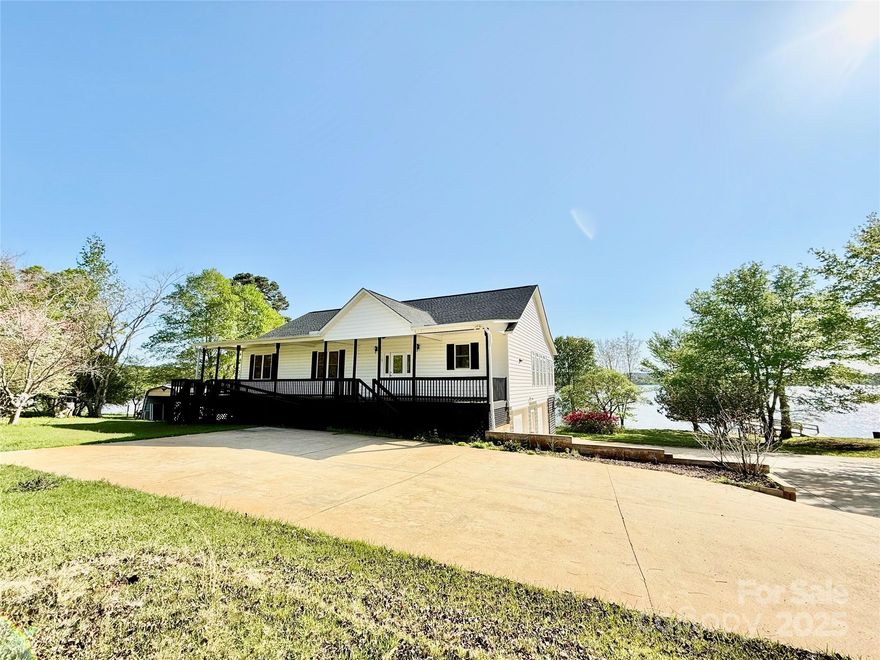 As if the almost 1 acre yard full of flowering trees weren't enough, you'll love all the space this home has to offer! Built in 2003, the home centers around a large spacious great room with vaulted ceilings and a sun room with a wall of windows that over looks the biggest part of Wateree Creek out to the main channel. Boasting real hardwood floors and large bedrooms, this home also has several walk in closets, tons of kitchen cabinet storage, a large eat in bar area and beautiful built-ins around the fireplace. The recently re-finished back porch is ready for rocking chairs so you can watch your horse neighbors across the street. There is also a large deck on the water side. All of this sits atop a huge basement with 3 bay doors for parking or entertaining. Beneath the sunroom is another enclosed storage area for yard tools or lake toys. The enormous concrete pad allows room for guest parking, boat storage, or yet another place to entertain.  So much potential! Come make it yours!