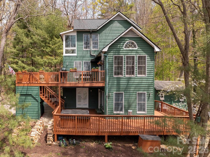 Enjoy life in the mountains in this custom designed, one owner home on Sunset Mountain.  Located just 10 minutes from the restaurants, shopping, and cultural offerings of Downtown Asheville, this home offers a vacation-like atmosphere surrounded by nature, privacy, and long-range views. The property even features a small creek fed by a natural spring. Multiple decks on two levels allow you to spend time outside and enjoy the nice weather.   Included is a Big Green Egg grill and a hot tub.  Built with high-quality materials—including 6-inch walls, copper guttering, cedar siding and Andersen windows—the home has been meticulously maintained. Updates within the last two years include a new roof, fresh exterior stain, updated bathrooms, and an updated kitchen with new appliances. Additionally, a new Trane heat pump was installed last year for the main levels. Special features include wood floors on the main level except for marble tile in the kitchen, cathedral ceiling and a palladium window in the dining room, a garden window in the kitchen, cathedral ceiling in the primary bedroom, a sunroom off the primary bedroom, a wood burning Jotul stove (complete with a supply of wood) in the living room, and a propane gas stove in the family room. A few steps from the lower deck is an auxiliary building with electricity that is used for a workshop.  It would also make a great studio or playhouse.  There is covered parking for 2 vehicles, plenty of room for additional vehicles and ample turn around space. For your piece of mind, a one-year 2-10 Supreme Warranty is provided. This might be a perfect home in the mountains for you.