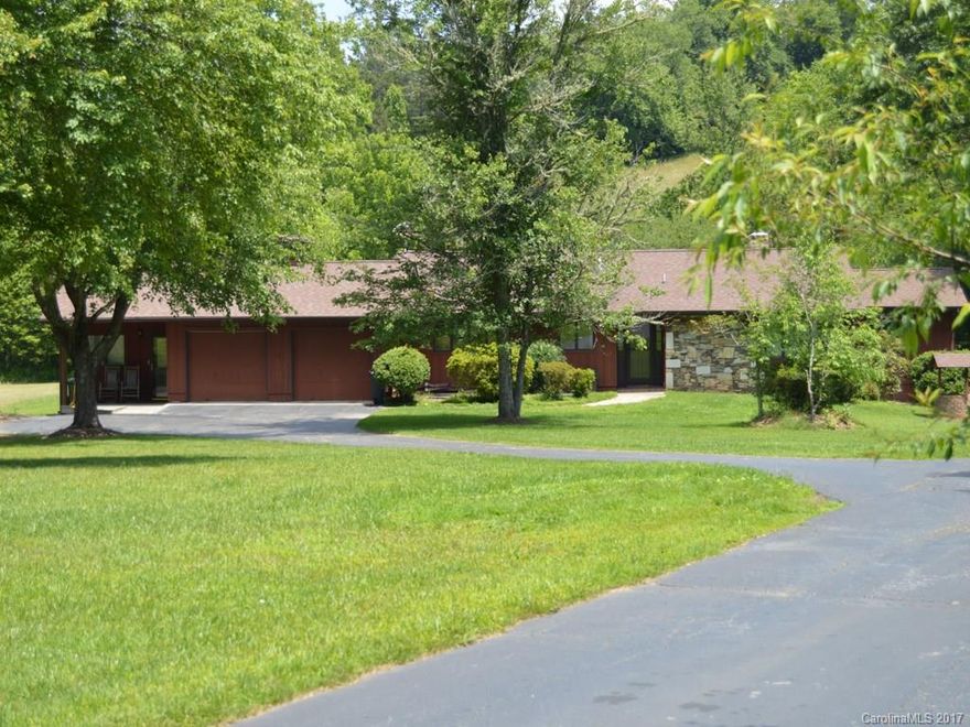 Spacious & private in Mills River. Modern one-level, open floor plan in a three-street neighborhood of acre-sized lots, community pond, close to Etowah Valley Golf. Well maintained and updated.  Lots of windows, gorgeous wood floors, closets, kitchen space, and exterior storage.  Separate quarters attached - could be great for extended family or rental.  Property offers ample parking, large garage, privacy, open back deck with hot tub, surrounded by larger parcels. Sellers are NC RE brokers.