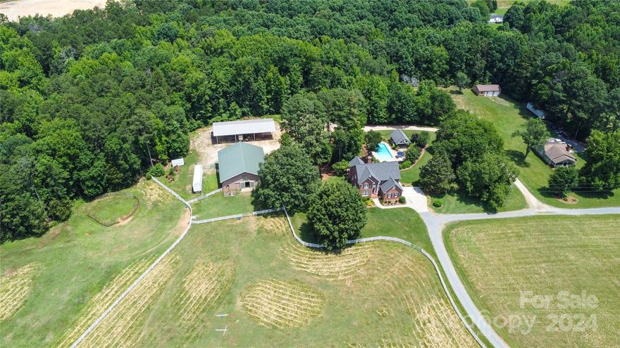 Escape to your own equestrian paradise at 5610 Golden Pond Road! Surrounded by 26 acres of rolling pastures this home boasts luxury equestrian amenities including: A horse barn with 6 stalls, a workshop, hay loft, tack room w/ private loft area, & over 8 acres of fenced pasture. This isn't just a house, it's a lifestyle. Imagine hosting friends and family in the separate guest house, complete with its own full kitchen, ensuring everyone has their own space. The expansive acreage offers endless possibilities: create a garden oasis, a private sports court, or a tranquil escape. Dive into cool refreshment on hot days with the sparkling in-ground pool. Relax and unwind under the covered outdoor lounge area, perfect for poolside lounging and entertaining friends and family. Inside discover a gourmet kitchen, spa-like bathrooms, and spacious bedrooms. Enjoy peace and quiet in prime Indian Trail, close to shops, restaurants, and top schools. Schedule your private tour today!

Use preferred lender to buy this home and receive an incentive towards your closing costs!