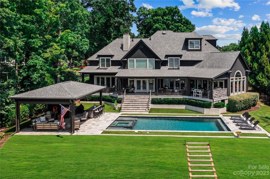 This luxurious estate-style home, lovingly renovated by renowned builder Ted Thompson, offers breathtaking views of Lake Norman and Peninsula Golf Course from almost every room. Anchored by nearly 800+ square feet of covered terraces above a saltwater pool surrounded by silver travertine & pool cabana w/ full outdoor bath. Pool cabane features an outdoor bar.  A sandy beach, large private pier & dock with new Hydro Hoist boat lift offer easy access to Lake Norman’s main channel. The main floor primary suite offers a spa-like experience, featuring dual custom closets and a quartzite counter w/ built-in storage. The kitchen includes walnut butcher block island, Thermadore appliances, quartzite countertops opens to a large dining area and lounge with a custom built-in bar and beverage fridge.  Home features 200+ bottles of tempature controlled wine storage.  The 2nd floor boasts 4 bedrooms & third floor features an additional guest suite. Luxury encapsulates every level.