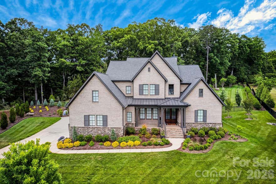 Arthur Rutenberg custom built brick and stone estate in the highly sought-after Stevens Grove community of Matthews, NC, is designed for entertaining and resort-style living. Privately situated on a quiet cul-de-sac, this residence blends timeless craftsmanship with modern luxury. The open-concept design creates a seamless flow between living spaces, great for everyday living and large-scale entertaining. A luxurious main-level primary suite serves as a private retreat with spa-inspired finishes, while additional ensuite bedrooms provide comfort and privacy for guests. Elegant architectural details and refined finishes enhance the home’s sophisticated character throughout. Outdoor living extends the experience with a serene, resort-like setting surrounded by lush landscaping, creating the perfect backdrop for relaxation and entertaining year-round.