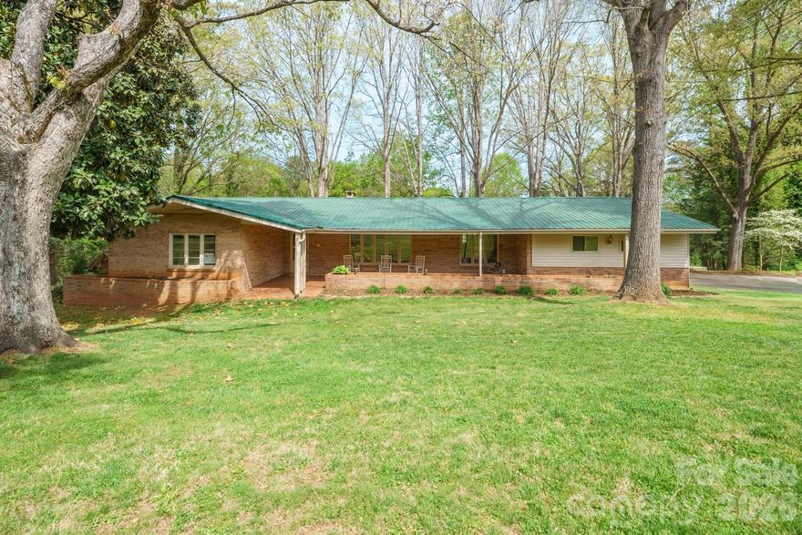 NE Hickory brick ranch on 1.46 acres featuring a remodeled kitchen, creek, and outdoor pavilion. A welcoming covered front porch offers the perfect spot to relax and unwind. Inside, you’ll find beautiful hardwood floors throughout the formal living and dining rooms, leading into a stunning, fully remodeled custom kitchen (2023) featuring quartz countertops, tile backsplash, custom cabinetry, center island with cooktop, wall oven (double ovens), stainlesss appliances, and LVP flooring. Refrigerator remains. Just off the kitchen, the keeping room/den with gas log fireplace opens to a lovely screened porch, ideal for year-round enjoyment. The primary suite offers a walk-in closet and private bath, while two additional bedrooms share a hall bath with dual sink vanity. A third full bath with walk-in shower is conveniently located off the kitchen. All bathrooms feature tile flooring. Additional highlights include a pantry closet plus a potential walk-in pantry and a centrally located laundry area. The full unfinished basement provides incredible potential, already featuring a full bath, gas log fireplace, multiple framed rooms with partial sheetrock (additional sheetrock remains), workshop space, abundant storage, and exterior access to a covered patio. Basement is vented, and gas logs are thermostat-controlled (per seller). Outside, enjoy a double garage on the main level, storage shed, and multiple driveway access points from both 28th Ave Ln NE and 29th St NE. The lower backyard is a true retreat—featuring a covered pavilion with seating, grilling area, and TV setup, perfect for entertaining and fall football gatherings. Explore the lush, level yard, relax by the creek, or enjoy the natural spring (previously used for outdoor spigots), which feeds into the creek when the water table rises. Located on a quiet, dead-end/cul-de-sac street. A rare opportunity combining space, privacy, updates, and future potential—all in a desirable Hickory location! Intercom & central vac are nonfunctioning.