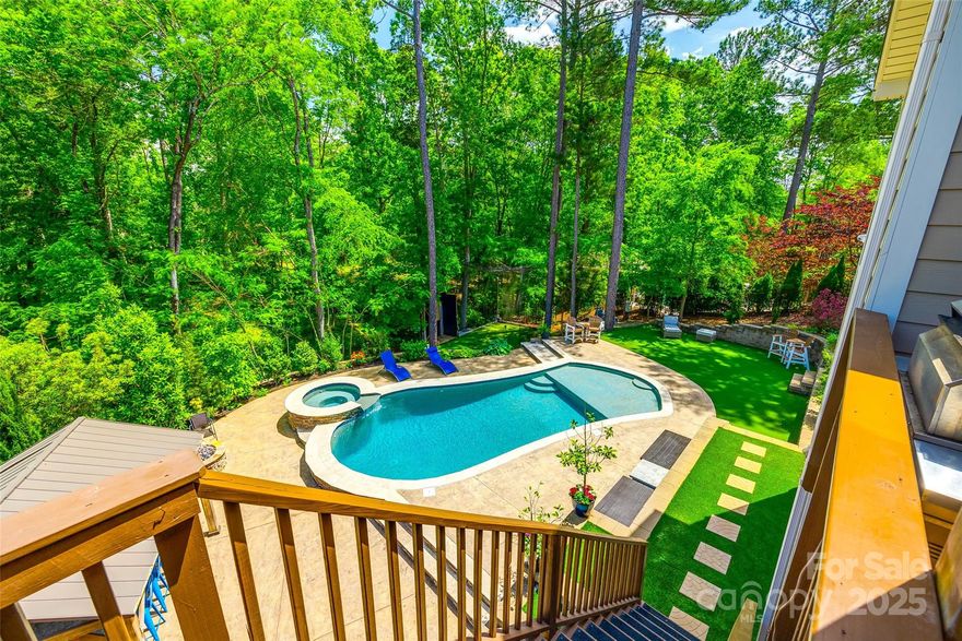 Step into your own botanical oasis-a private retreat designed for luxury living and unforgettable entertaining. The backyard features a resort-style pool with an extra-large Baja shelf, travertine sitting ledge, hot tub, outdoor firepit, sports zone, and fully equipped outdoor kitchen with high-end appliances—all within a fenced yard offering total privacy. Inside, enjoy a gorgeous custom kitchen with top-tier appliances, walk-in pantry, walnut shelving, and stunning finishes throughout. The main-level primary suite offers a spa-like escape with customized walk-in closets. The open layout showcases super durable, highest-grade LVP flooring that combines beauty and function. A spacious 3-car garage includes a 220V outlet and sealed storage. Located in a lakefront community with pool, playground, kayak launch & boat/rv storage near shopping & restaurants—with low SC taxes. this home offers the perfect blend of style& convenience. Ask for list of exceptional features.Video available