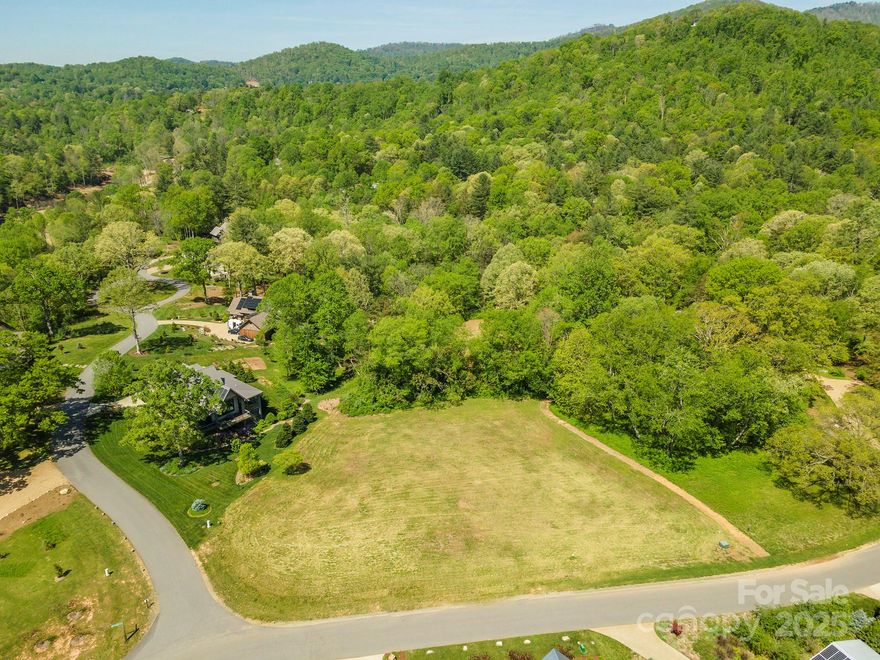 Nestled in a serene, forested setting within the coveted Sovereign Oaks community in East Asheville. Discover the rare opportunity to build your dream home on 2 level acres approximately 7 miles from vibrant downtown Asheville. All utilities are underground. Wonderful mountain views throughout the community. City water available; septic system required and you can have propane gas. Sovereign Oaks promotes green building practices, with design guidelines encouraging low-impact construction and renewable energy solutions. Perfect for those seeking a lifestyle in harmony with the environment. Enjoy access to community trails connecting to the trail system at Warren Wilson College. Close to Black Mountain as well as the Asheville VA Medical Center.