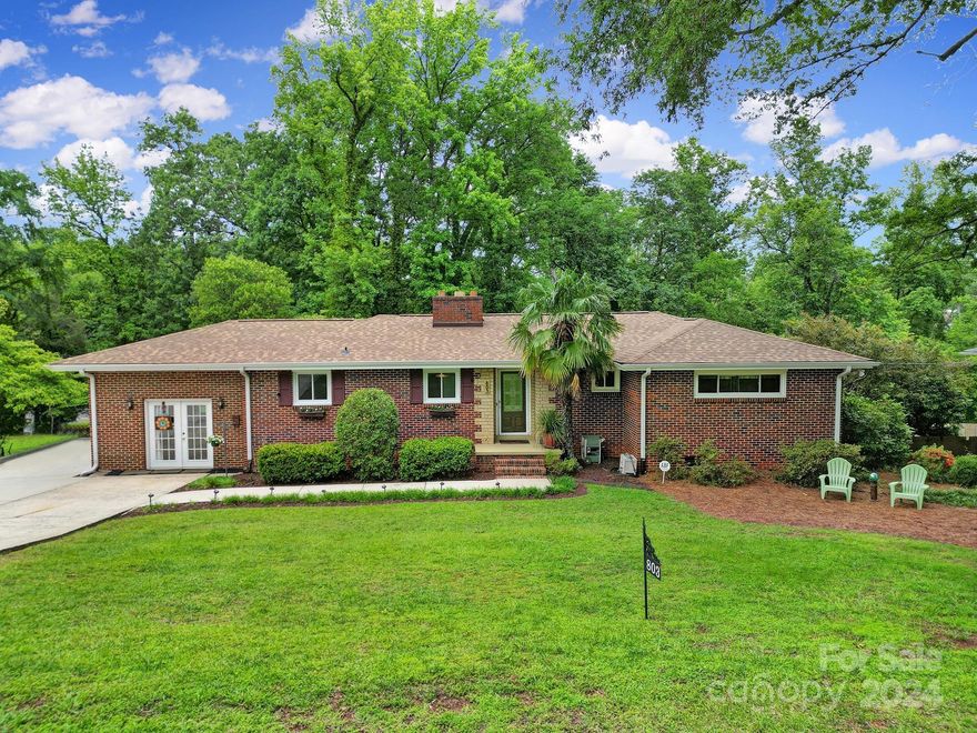 Welcome to this rare-for-the-Carolinas, full brick basement home with no HOA. There's no lack of curb appeal w/mature landscaping, palm tree, extra parking spot for RV with 30 amp hookup & brand new roof as of May 2024. Step inside to find lots of natural light beaming in the main living area. Notice the character all around w/ the fireplace, built-ins, crown molding, & a dutch door leading you from the galley style kitchen into the den. Head down the hallway to find 3 bedrooms & 1.5 bathrooms. Go downstairs to find the basement w/more living space, laundry, bedroom, full bathroom, & ample storage. Plenty of room to entertain/relax outside in your fenced backyard w/ patio area, hot tub, covered deck area for watching TV & covered grilling station. Located in the heart of Rock Hill with easy access to schools, breweries, & restaurants and an easy commute to I-77. One bedroom on the main has a cabinet instead of a closet, & otherwise meets the definition of a bedroom, per Canopy MLS.