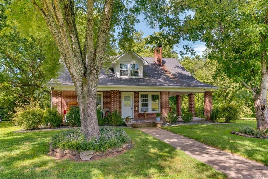 Rare historic 1930s brick farm style house on 1.78 acres. Beautifully landscaped fully fenced yard, nice level ground for gardening & outdoor activity.  4 BD, 2 BA, living room, den, open plan.  Light bright kitchen w/ skylight & loads of cabinets & ceramic counter tops. Master suite complete w/dressing area, large walk-in closet & bathroom. Tons of storage for a house of this era.  Covered wrap around porch.  Close to town but wonderful country feel. Convenient to Asheville, Charlotte and TIEC.