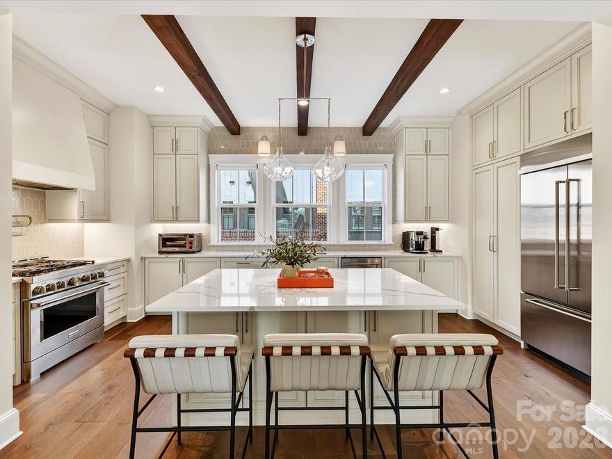Discover sophisticated, low-maintenance living in this exceptional END UNIT Myers Park luxury townhome, perfectly positioned just steps from the Greenway, Park Road Shopping Center, dining, and everyday conveniences. 2 Car SIDE by SIDE garage. Thoughtfully designed across multiple levels, the home features a private lower-level guest suite with a full bath—ideal for visitors or flexible living. The main living areas flow effortlessly, offering both comfort and style. Featuring gourmet kitchen with KitchenAid appliances including 36" gas range with custom hood, pot filler, built-in refrigerator, dishwasher & Sharp drawer microwave. Huge island, perfect for entertaining. Open floor plan features dining area and family room with access to front covered balcony. The upper level is a true retreat, highlighted by a luxurious primary suite with a dual-sink vanity and walk-in shower featuring a rain shower head. An additional bedroom with ensuite bath and a conveniently located laundry room with cabinetry and sink complete this level. On the Upper level, an incredible private office with its own half bath is paired with a stunning entertaining space, complete with a custom bar, sink, ice maker, and two-drawer refrigerator. This level opens directly to the rooftop deck, creating the ultimate indoor-outdoor experience. Perfect for entertaining or unwinding in style. Elevated finishes, and an unbeatable walkable location, this Myers Park residence offers a rare blend of luxury, functionality, and lifestyle.