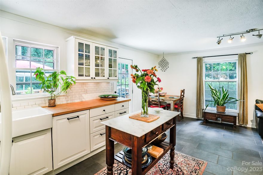 THE house in THIS location for under 500k!  The white picket fence and front gate at 311 W Lake Street welcome you to a charmed ranch-style bungalow adjoining a protected bird sanctuary and forest. Only 1 block from the Ecuesta rail-to trails and Trailside Brewery and less than a mile to Main Street in burgeoning downtown Hendersonville. Convenience with privacy. A mid-century gem with modern features, fiber optic internet, updated kitchen, stone fireplace, fenced back yard, firepit and a gated front yard. Spacious 3-2 configuration, off driveway entryway and full basement with shop and open office behind a sliding barn door. Plumbed space for another bathroom. This is a DNM (do-not-miss) opportunity for your Hendersonville home or a top shelf rental property for your portfolio.