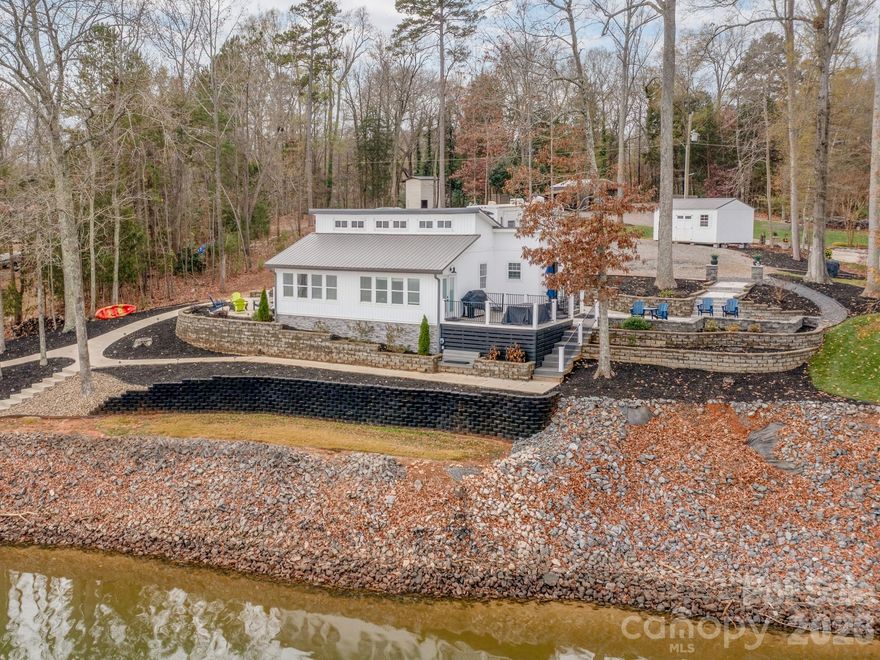 This Nearly New Construction Waterfront Ranch home offers over 233 feet of shoreline in one of the Largest Big-Water views on Lake Wylie! It blends modern updates with charming character from the original home, including large wood-beamed cathedral ceilings. It captures stunning panoramic water views, along with spacious patios overlooking the big water! Get your Lake Toys ready with a new covered stationary Dock & Boat Lift! Have the freedom with Privacy and No HOA! Home sits nearly on a 1 acre main-channel waterfront lot w/ too many upgrades to list including new roof, septic, well, windows, high-end quartz counter tops in kitchen & baths, & the list goes on. The large chef's kitchen features stainless steel appliances, high-end custom cabinetry, generous counter space w/ a massive breakfast bar. The primary suite includes an en-suite bath, a large tile shower, a roomy closet, and private access to a patio w/ a fire pit. This home is close to all the lake lifestyle conveniences, top Dining, and shopping, while being in a Top Tier School District that is only 20-25 minutes from Uptown Charlotte.