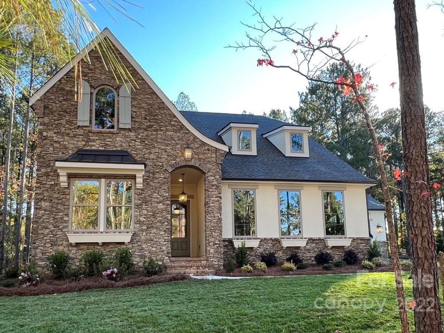 This lovely European Cottage Balboa  is located in Lancaster, SC in the stunning, tranquil community of Riverchase Estates, a quiet, gated, luxury community with homesites nearly an acre or larger, located on the shores of the Catawba River. Riverchase Estates, a perfect escape from the hustle and bustle -is only a 40 minute drive to Charlotte and only 25 minutes to Ballantyne. Homeowners enjoy a club with fitness center & ballroom, pool, basketball courts, tennis & pickle ball courts,  & miles of walking trails leading to Catawba River access.  This beautiful Balboa home features a living/dining nook area open to the kitchen, with a 27' wide outdoor living room with outdoor fireplace. Owner's Suite with box bay sitting area, is private for a true retreat feel, with spacious spa shower & large closet. Guest Suite with full bath/shower rounds out the first floor. Upstairs are two bedrooms with two private baths, large bonus, media room, exercise or 2nd office, second laundry & storage.