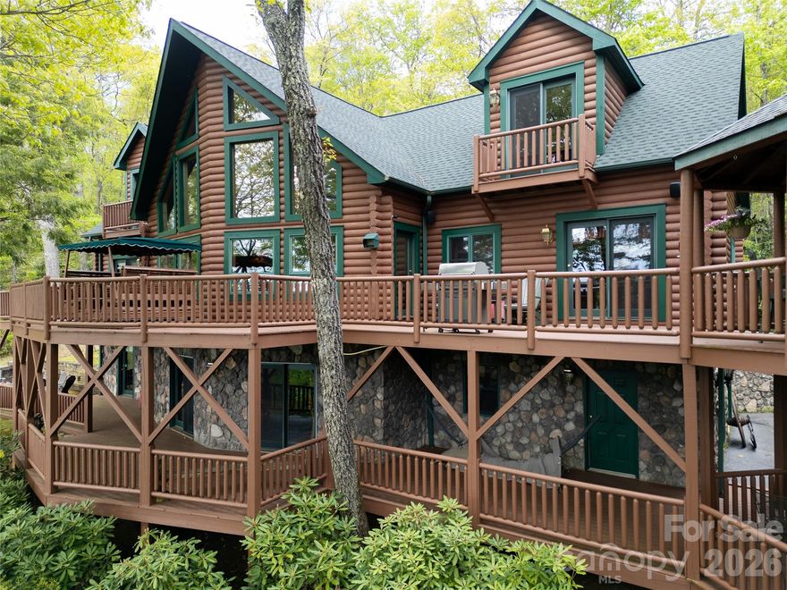 Inspired by the spirit of Breckenridge ski lodges and designed for gathering, Falcon Crest Lodge is a private mountain retreat where weekends become traditions and memories are made for generations. Set at an awe-inspiring 4200’ elevation on over 3 acres, this gated estate captures sweeping long-range views from Maggie Valley’s valley floor to its surrounding mountain ridges. 

Crafted by respected local builders, the home blends authentic lodge architecture with exceptional craftsmanship and spaces designed to bring people together. The soaring two-story great room features a dramatic wall of windows, massive stone fireplace, vaulted tongue-and-groove ceilings, Hickory floors, and custom antler chandeliers sourced from Montana. 

The expansive floorplan was created for entertaining on every level. Multiple gathering spaces include a chef’s kitchen with custom Hickory cabinetry, large dining areas, expansive covered decks, a lower-level game and billiards lounge with custom bar and fireplace, outdoor firepit area, gazebo, and numerous spaces to relax after a day of adventure in the mountains. 

The main-level primary suite offers a private fireside retreat with deck access, while upper guest bedrooms each enjoy their own mountain character and balcony access. Bonus and flex rooms on the lower level provide additional sleeping, office, recreation, or retreat possibilities.

Outside, the experience continues with gated access, ample parking, detached workshop/studio space, separate playhouse, newly stained and sealed exterior, and new roof in 2024.  The detached workshop is a standout feature with electricity, wood stove, and exceptional versatility as a hobby space, game room, studio, gathering space, or creative retreat. The separate playhouse/studio also offers electricity and charming additional flex space tucked just below the home.

Whether envisioned as a luxury mountain getaway, unforgettable vacation rental lodge, corporate retreat, or legacy gathering place for family and friends, Falcon Crest offers a rare opportunity to own a true Blue Ridge destination property just minutes from the heart of Maggie Valley.
