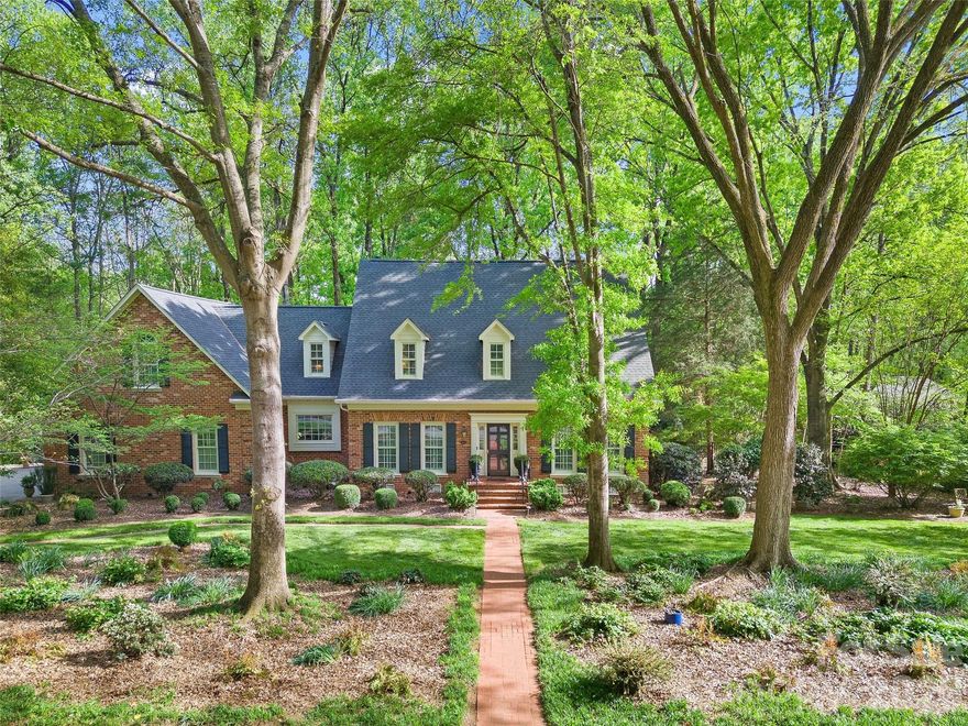 Gorgeous custom brick home set on a rare, picturesque .90-acre lot in sought-after Carmel Estates West, in close proximity to the south course at Carmel Country Club! This one-owner residence has been impeccably maintained and offers exceptional privacy, with lush, mature landscaping and charming garden spaces. Offering 4 bedrooms, 2.5 baths, and 3,600+ square feet, the home blends classic character with comfortable living. The main level features beautiful hardwoods, formal dining, and a spacious family room with built-ins, gas fireplace, and wet bar. The light-filled sunroom and expansive rear deck overlook the sprawling, private backyard—perfect for entertaining or everyday enjoyment. The kitchen includes an abundance of white cabinetry, granite countertops, Thermador appliances, walk-in pantry and a sunny breakfast area. Main-level primary suite with walk-in closet and spa-like bath with soaking tub. Upstairs offers three spacious bedrooms and large bonus room. Ample storage in the walk-in attic or attached 2-car garage. A truly special property with unmatched outdoor space and privacy, just minutes from Carmel Country Club, Charlotte Country Day, and all that south Charlotte has to offer!