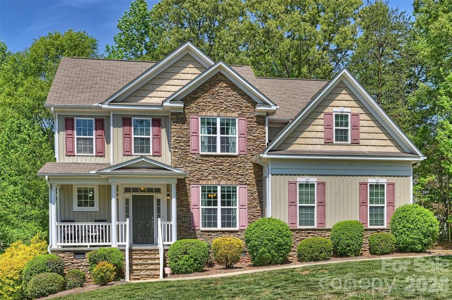 Tucked on a desirable corner lot, this home offers one of the more private, wooded settings in the sought-after Gates at Waterside community—complete with clubhouse, outdoor pool, playground, and sidewalks for easy neighborhood living. A classic rocking chair front porch welcomes you in, where wood floors and an easy, open layout make the main level feel both functional and relaxed. The kitchen is well-appointed with granite countertops, tile backsplash, stainless appliances, recessed lighting, and a breakfast bar and casual dining area that overlooks the rear deck and peaceful, wooded yard. Just off the kitchen, a formal dining room with coffered ceiling and a cozy family room with gas fireplace offer great spaces to gather.

A main-level bedroom and full bath provide flexibility for guests, work-from-home, or multigenerational living. Upstairs, the spacious owner’s suite feels like a true retreat, with a large walk-in closet, dual vanities, and a separate garden tub and shower. Three additional bedrooms, a shared bath with dual sinks, and a generous ~320 SF loft give everyone room to spread out.

A full-size laundry room with storage and a side-load 2-car garage round out the home. All of it, set in a community people love—this one just happens to come with a little extra privacy out back.