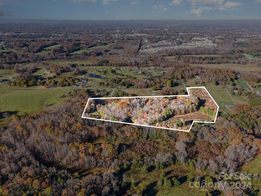 Welcome visionaries! Are you ready to build your dream sanctuary upon a secluded expanse of just over 30 acres, complete with your very own self-sustaining pond for endless enjoyment? Or perhaps you are a builder, envisioning the potential this land holds for a new subdivision with 210 feet of road frontage and 2 wells already onsite. If constructing anew isn't your interest and looking to revitalize the existing charm, check out the 2,308 sqft farmhouse adorned with a lovely wrap-around porch. Additionally, the property is home to a historic schoolhouse, lending its name to the road and offering the opportunity to preserve the legacy of the land. While the property is tucked away, it is still located within 10 minutes from the newly built Publix as well as vibrant downtown Mooresville, where you can enjoy a variety of restaurants and local shopping. Less than 20 minutes to i77, completes this ideal location to call home. Come take a look and see what you envision!