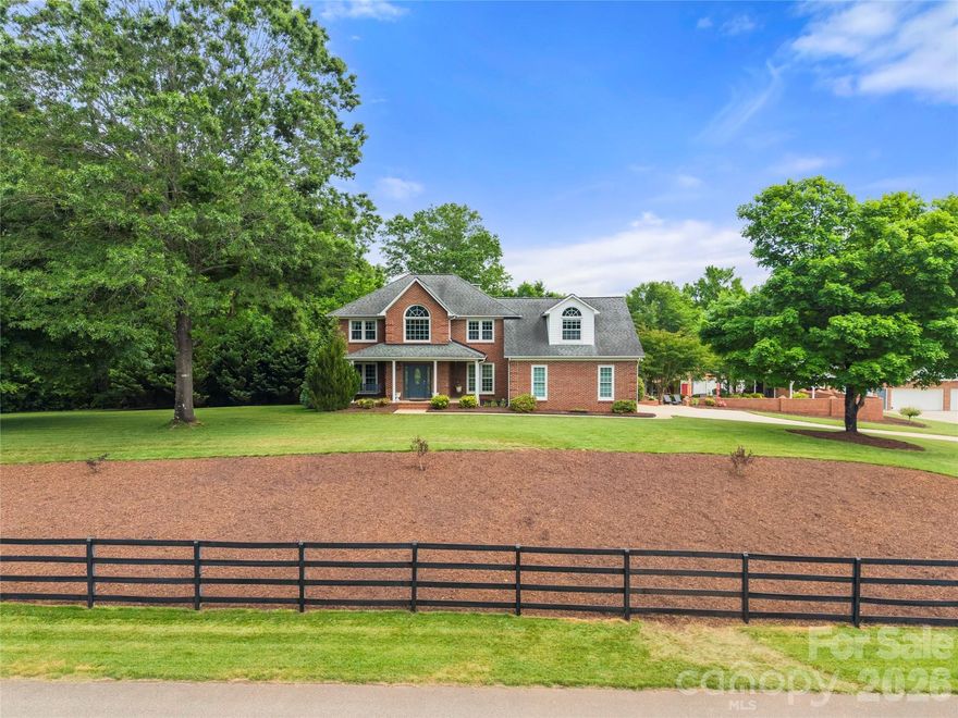 This beautiful, private 5-acre property features a full brick 2-story open floor plan home with primary bedroom on the main level. The recently remodeled gourmet kitchen offers marble counters and island, custom cabinetry, subway tile backsplash, pendant lighting, and stainless steel appliances including a double oven and microwave. The 2-story great room is ideal for entertaining and features a large brick fireplace, covered front porch, a back porch, and a spacious deck that overlooks the wooded landscape. The 17’ x 35’ custom saltwater pool with Pebble Tec finish is complemented by a large concrete surround, brick privacy wall, and pool house with covered cabana, patio, kitchenette, full bath, and a mini-split system, perfect for guests or flexible use. Additional features include a detached oversized 4-car garage with workshop, RV/camper carport, tractor barn, greenhouse, fenced garden, and chicken coop with run. Backyard includes invisible fence and separate dog yard. Interior highlights include hardwood floors, ceiling fans throughout, laundry room with sink, and main-level primary suite with dual walk-in closets. Upper level offers two bedrooms, full bath, bonus room, and loft with built-ins. Recent updates include renovated kitchen (2023) and new high-efficiency HVAC systems (2024 & 2025).