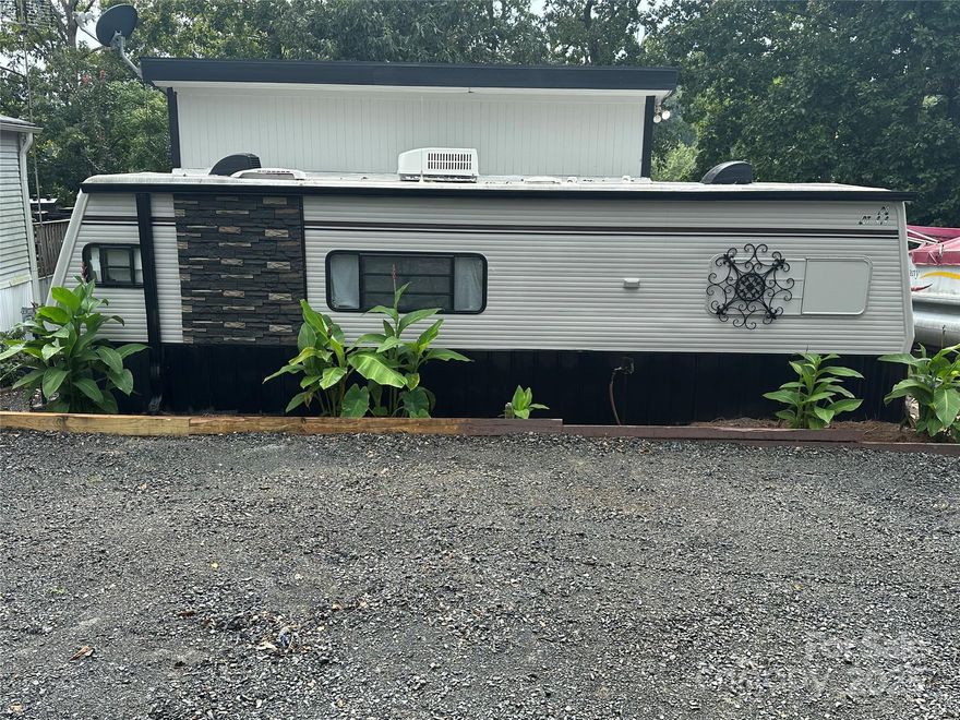 Nicely updated camper with room addition located in the lake front community of Badin Shores Resort. The camper bathroom has been removed and more storage added in that area along with a full-size bathroom added in the room addition. Then step out on the back deck and enjoy the lake view. The property also has great parking for all your cars, trucks, boats, and golf carts. The resort has pool, beach area, restaurant, club house, playground, boat ramp, putt putt, basketball courts, and all paved roads.