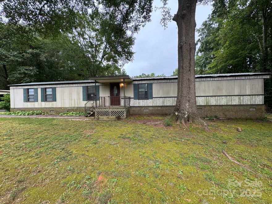 Welcome Home to a well kept single wide on a great lot.  Enjoy relaxing on the closed in back porch or by the fire pit. The out building was constructed by trees from the yard and the carport will stay. Lawnmower and tiller are negotiable.