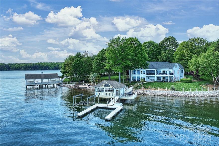 Discover one of Lake Norman’s most spectacular property with unmatched panoramic views across expansive water. A unique & incredible setting–unparalleled on all of Lake Norman with approx 600 ft of shoreline. Lovely shade trees yet panoramic main channel views throughout. Extensive renovation delivers a “modern new yet charming” feel. 1st floor features great room with cathedral ceiling, gas fireplace & wall of windows to enjoy the views, a spectacular gourmet kitchen with a Wolf 48” double oven, two islands, extensive custom cabinetry, and a spacious Primary bedroom and bath renovated 2021. Lake level w/ 2 large bedrooms (second Primary) & renovated baths, a large media room & wet bar. Multiple outdoor living spaces, including covered screened porch, spacious deck, lake level terrace, beach area and one w/ unique air conditioned boathouse bar & a seating area over the lake!  Adjacent 1.4 acre lot is for sale separately. PROPERTY SOLD WITH ADJACENT LOT FOR AN ADDITIONAL $1,000,000.