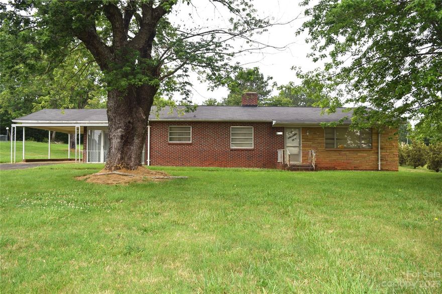 Brick ranch home with three bedrooms and a bath located in the Town of Rhodhiss. With needed updates, would make a fabulous home! Spacious with large backyard! The home has a 1-car caport and extra parking in the driveway. Large sunroon (not heated or cooled). Kitchen with eat-in area. Large living room. Currently well water, but there is a tap for public water access. Septic system  – no county records. Home to be sold “as-is”.