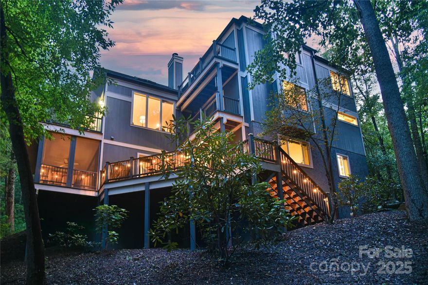 Tucked away in charming Black Mountain, this one-of-a-kind home offers convenient seclusion and timeless appeal. Each level boasts a private primary suite and large porches or private balconies are accessible from nearly every indoor living space. At the heart of the home is a gourmet kitchen—beautiful granite counters and backsplash, abundant natural light, and excellent workflow—flowing into a cozy Keeping Room with a floor-to-ceiling stone, wood-burning fireplace, and then into the most perfect sunroom surrounded by trees on three sides. The lower level, a proven short- and long-term rental, is sure to impress with a rec room (pool table, gas fireplace), 9-seat theater, full kitchen, and private screened porch. Every detail of this exceptional home is thoughtfully designed for comfort, warmth, and grace—perfect for large gatherings or quiet mornings alike.