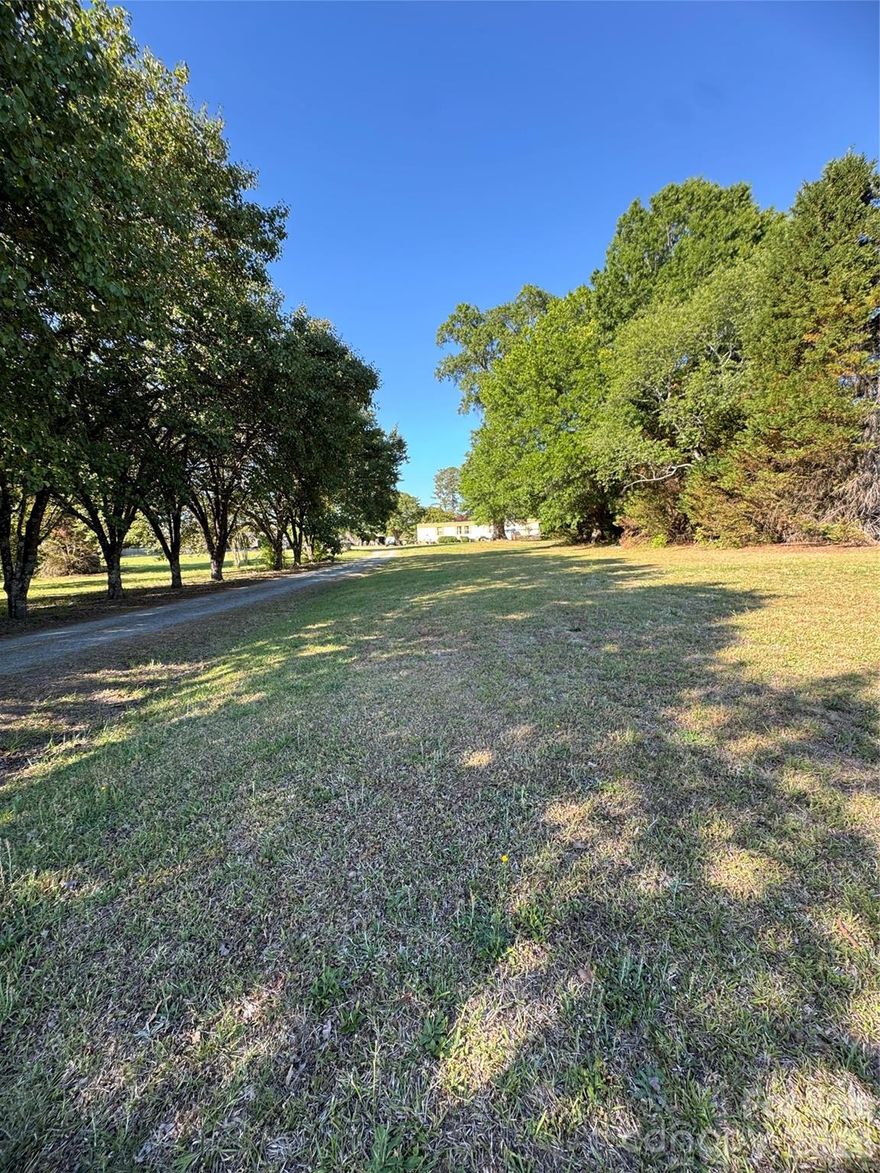 Rare opportunity in the growing Matthews area! 3227 Pleasant Plains Road is being sold together with 3207 Pleasant Plains Road for a combined total of +/- 4.381 acres ($1,900,000 combined list price). This beautiful property features a manufactured double-wide home, barn, and a stunning long tree-lined driveway that creates a private and peaceful setting. Both parcels have a private well, and fence line at the back of the properties. There are also multiple water spigots throughout the property. 
Per the Town of Matthews Future Use Plan, the property is designated Living One, offering exciting potential development opportunities including large lot single-family detached homes, medium lot single-family detached homes, small lot single-family detached homes, attached single-family homes, duplexes, triplexes, and additional residential possibilities.
Conveniently located near shopping, dining, and major roadways while still offering the charm and space of living right outside Charlotte. Whether you are looking for investment potential, development opportunities, or acreage to enjoy, this property offers endless possibilities. Don’t miss this unique opportunity — properties like this do not last long!