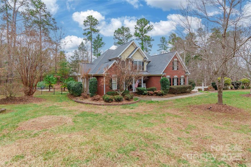 This stunning 4 bedroom, 2.5 bathroom home in the desirable Mariners Bluff community showcases exceptional details throughout. Hardwood floors extend through the main living areas, complementing the vaulted ceilings and cozy fireplace in the living room. The kitchen features granite countertops and stainless steel appliances, while the main-level primary suite includes a full ensuite bathroom with a relaxing jetted tub. Upstairs, three additional bedrooms provide flexible living space. The fourth bedroom does not have a closet but offers a door to access storage. Situated on approximately 1.5 acres across two parcels, the outdoor area includes a spacious screened porch leading to a large two-level deck overlooking the expansive yard with a firepit. An irrigation system ensures a well-maintained landscape. Conveniently located with close proximity to the Allison Creek Park Boat Ramp and Handsmill Highway, providing easy access to the town of Lake Wylie and nearby amenities.