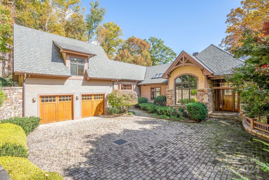 HUGE PRICE REDUCTION! Expertly crafted 5,280 sf luxury home with stunning mountain views.  Majestic free standing stone fireplace highlights the main living space. Custom kitchen with solid cherry cabinets, pantry, coffee bar and center island. Main level primary bedroom/bath suite with two 10x12 walk-in-closets, laundry room, half bath and sunroom that could be used as an office.  3 season vaulted screened porch, open decks, and two car garage are all accessed from this main level. Upstairs is a full guest suite with private bath, walk in closet & sitting area.  Downstairs offers another complete bedroom suite in addition to a family room with fireplace, office, bonus room, and half bath.  Walk out the sliding glass doors to exquisite stone patios, landscaping and rock work. Over 2 private acres within the Brights Creek Community, ability to add a golf or a social membership. Community features include dining, pool, fitness center, hiking trails, pickleball, tennis, equestrian & more.