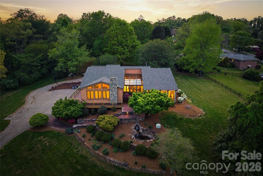 Nestled on over 10 stunning and flat acres, this property offers an extraordinary blend of convenience and tranquility!!

Located adjacent to the Lenoir Greenway and just minutes from downtown. Enjoy easy access to Highway 321, making trips to Boone and Blowing Rock a breeze. You can even stroll to the Greenway directly from your backyard, enhancing the appeal of outdoor living. The home features a brand-new wraparound back deck with durable Trex decking, perfect for entertaining or simply relaxing while enjoying the scenic surroundings.

As you enter, the inviting garden room welcomes you with large windows that frame picturesque views of Hibriten Mountain. Italian porcelain tile seamlessly extends into the kitchen and breakfast areas, complemented by exquisite built-in shelves and cabinetry throughout. The main level hosts a spacious primary suite, complete with a beautifully remodeled bathroom and a generous closet. Three additional bedrooms, a laundry room, and two more full bathrooms ensure ample space for family and guests. The home is open, bright, and charming throughout, creating a warm and inviting atmosphere.

The lower level features a fully equipped apartment with a kitchenette, an additional bedroom, living area, game room, and fitness space, along with a utility and storage room, all accessible from a four-car garage.

The backyard is a serene oasis, showcasing a back patio that overlooks a fenced-in yard, perfect for gatherings or quiet evenings. A larger detached garage complements the property, featuring a barn with a two-car garage and a built-in grease pit, ideal for car enthusiasts.

This property is a rare gem in the area, enhanced by beautiful landscaping and an abundance of natural light throughout the home. With its unique features, spacious layout, and prime location, this property is an unparalleled opportunity for those seeking a blend of rural charm and urban convenience!