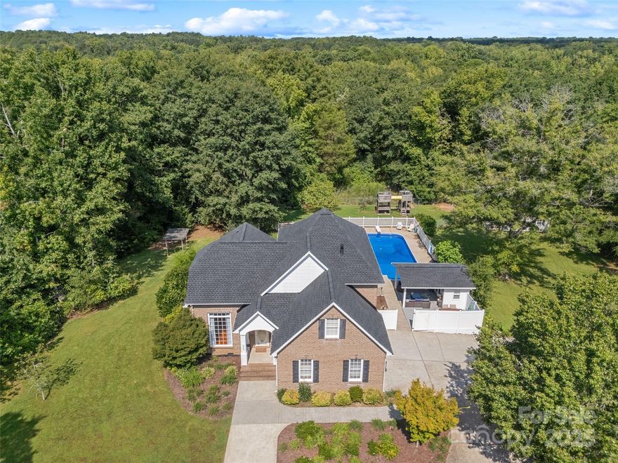 Welcome to your private retreat just minutes from Rock Hill! Nestled on 12.43 acres of hardwood trees, this charming brick home offers the perfect balance of comfort, convenience, and outdoor living. A circular drive through a hardwood tree canopies welcomes you to the property you have been waiting to hit the market.  The backyard is fully fenced and designed for relaxation and entertaining, featuring an inground pool with an outdoor living area and half bath—perfect for summer gatherings. Also for the outdoor enthusiasts, you will find a large shop with RV storage, 2 large enclosed bays and storage area. There is even a treehouse for the young ones!
The home is move-in ready with a new roof and HVAC system (2024), giving you peace of mind. With acreage to explore, room for hobbies, and spaces for everyone to enjoy, this property combines rural tranquility with easy access to city conveniences.
Don’t miss this opportunity to own your own slice of paradise close to Rock Hill!