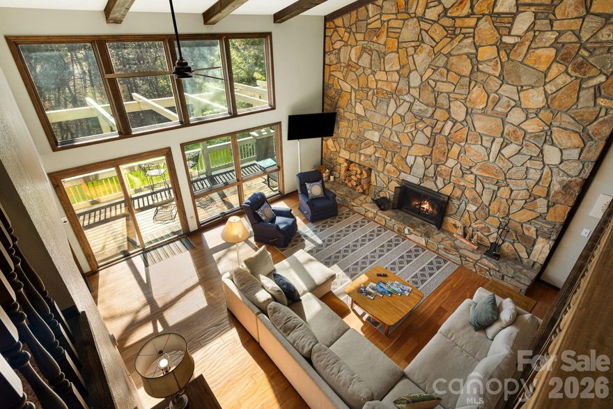 Positioned along the 13th fairway of the private, member-owned Wolf Laurel Country Club and set at an elevation of approximately 4,100 feet, this distinctive mid-century modern home offers a rare blend of architectural character, golf course frontage, and turnkey convenience within one of Western North Carolina’s premier mountain communities.

Designed to emphasize natural light and connection to the outdoors, the home features soaring vaulted ceilings, expansive walls of glass, and an open, flowing layout that brings the surrounding landscape into the living space from nearly every angle. The dramatic great room is anchored by a floor-to-ceiling stone fireplace and opens to an expansive deck overlooking the course. The open-concept design flows into the kitchen and dining areas, with multiple access points to expansive decking that extends the living space outdoors.

A defining feature of the property is its unique golf course and mountain corridor view. The home’s positioning captures a layered perspective—following the 13th fairway across the green, over the 14th tee box, and continuing down the 14th fairway toward the surrounding mountain ridgelines. While more focused in width, this alignment creates a dynamic and visually engaging setting rarely found in the community.

With approximately 550 feet of golf course frontage, the property offers an exceptional sense of openness and space. The ~1.75-acre homesite is notably large for Wolf Laurel and features a gentle, usable topography—an uncommon combination at this elevation. Mature hardwoods, rhododendron, and native landscape elements provide a private, park-like setting with natural separation from neighboring homes, while small natural streams enhance the property’s character and sense of tranquility.

Offered fully furnished, the home conveys with all contents, providing a true turnkey opportunity for immediate enjoyment, second-home use, or continued vacation rental potential. Vacation rentals are not prohibited within the community, subject to applicable guidelines and restrictions.

Well-proportioned bedrooms and flexible living areas provide comfort and versatility for both everyday living and hosting guests, offering a balance of openness and privacy.

Located within the gated Wolf Laurel community, the property offers access to year-round recreation including golf, skiing at Hatley Pointe, dining at Smoke and Timber, and extensive hiking and biking trails, including access to the Appalachian Trail. Additional amenities may be available through optional memberships at the Wolf Laurel Country Club and Village Club. Wolf Laurel is approximately 27 miles from Asheville, providing convenient access to a vibrant regional destination known for its craft breweries, diverse dining scene, live music, and year-round entertainment.

Combining architectural distinction, elevation, golf course frontage, and a uniquely framed mountain view, this property represents a rare opportunity to own a truly distinctive mountain retreat.