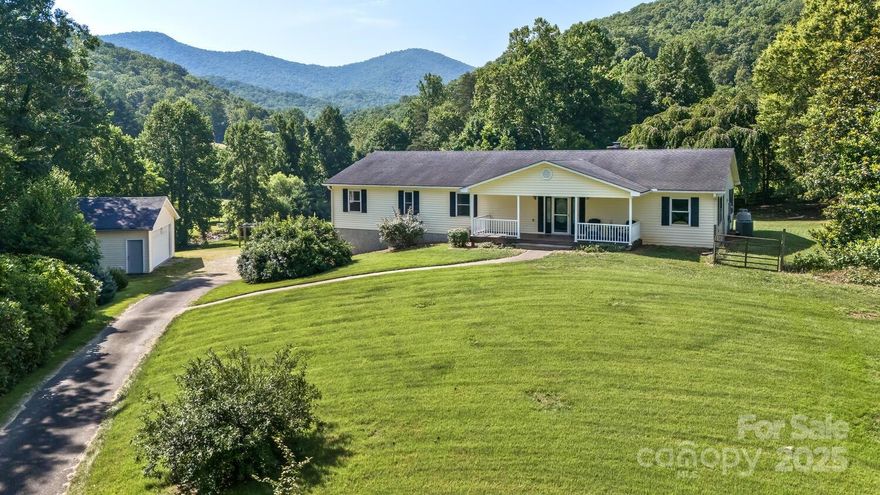 Beautiful 3BR/3BA Home on Nearly 5 Acres with Epic Mountain Views! This private mountain retreat offers serenity and convenience with a bold creek, open meadow, mature woods, and stunning rock outcroppings. The open-concept main level features a spacious living area with wood stove, and entertainer’s kitchen. The main-floor primary suite includes a large en-suite bath and walk-in closet, plus two more bedrooms and a full bath.  Multiple bonus rooms, and over 1000 sf of covered porch area for expanded living. The finished walk-out basement with full bath has a strong short-term rental history. Abundant parking and extra space with both two-car attached and detached garages, and two full RV spots. Just 20 minutes to bustling downtown Asheville.  Across street from a large community park.  Open-Use zoning with direct access to 6+ miles of forest trails and the Blue Ridge Parkway—perfect for nature lovers. Ideal as a full-time residence, or vacation home—this one checks all the boxes!