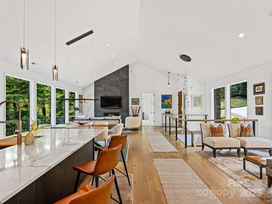 Step into this stunning modern home—a true life-size treehouse with unparalleled privacy. The open-concept great room features soaring 18' ceilings and a striking fireplace wall that anchors the space. Walls of floor-to-ceiling picture windows flood the home with natural light while immersing you in nature's serene surroundings. At the heart of the home is a chef’s kitchen designed for entertaining, showcasing custom Cabico cabinetry, quartz countertops and dramatic island, and premium SubZero, Wolf, and Cove appliances. Retreat to the home office—a serene space for creating or peaceful reflection. The terrace level offers well appointed guest spaces with premium tile and designer finishes. Enjoy comfort year-round with three zoned HVAC—one per level and one dedicated to the primary suite—and a whole-house Generac generator. Designer lighting enhances each space, adding warmth and ambiance throughout. Blending sleek design with warmth and comfort, this home inspires at every turn.