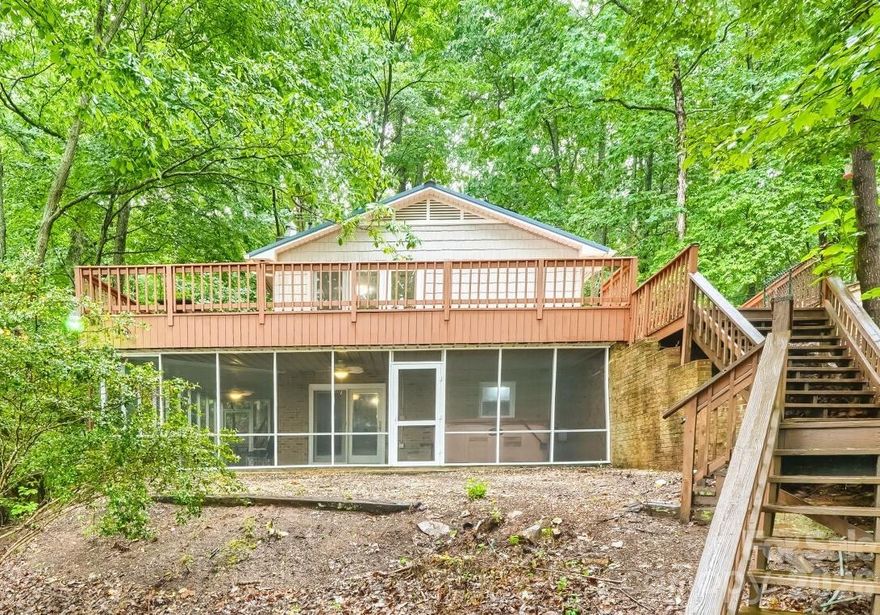 Check out this gorgeous lakefront retreat on Badin Lake situated on a private 1.22-acre lot with breathtaking views of the Uwharrie Mountains and National Forest. This beautifully updated cottage offers the perfect blend of privacy, comfort, and lake living. The cottage has new LVP flooring on both levels. The kitchen has been completely refreshed with granite countertops, backsplash, appliances, sink/faucet, lighting, and fresh paint. The living room features updated lighting, and fresh interior paint, creating a bright and inviting space to relax and enjoy the breath taking views. Enjoy cozy evenings by the wood-burning fireplaces located in both the main-level living room and the lower-level entertainment room. The bedrooms have also been updated with paint throughout. Also take a look at the gorgeous remodel on both bathrooms. Additional improvements include a refinished staircase leading to the charming rustic style basement, a fully functioning second kitchen with new granite counter-tops, beautiful backsplash, and new basement appliances, and an entertainment / family room with updated lighting. While the lower level bed/bonus room offers a closet, there are no windows. Outdoor upgrades make this property even more impressive with a fully screened wraparound slate patio complete with a hot tub, a freshly stained/painted wrap around upper deck, new water lines, and a new well pump system. Enjoy peace of mind with a metal roof less than five years old, chain-link fencing for added privacy, and multiple storage options with a workshop/storage shed and an additional storage building located close to the pier. The true showstopper is the waterfront setting, with easy access to the lake and pier by either stairs or driveway. Enjoy peaceful lakefront living with stunning year-round views of the mountain and national forest in this move-in ready getaway.