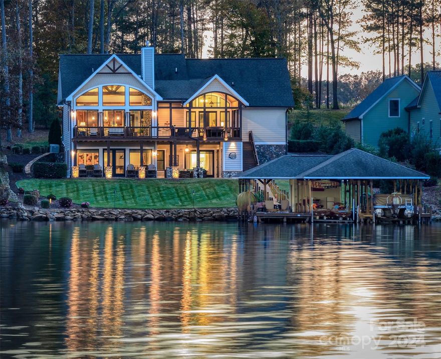 Capture nature and lake living in harmony  at "Eagle’s Rest", a Modern Craftsman Lake Home. Idyllically designed and perfect for entertaining, with custom details throughout. The Scenic Level boasts expansive open spaces, 3 fireplaces, hickory hardwood flooring, a great room with soaring 21 ft beamed ceiling, a wall of windows that capture the natural light, dining area, custom open kitchen with island, custom cherry/walnut cabinets, walk-in pantry, owner’s en suite bedroom with 19 ft ceilings, and expansive porches with commanding views of the lake. The Lake level with open recreation/family room, mini-kitchen, en-suite guest bedroom overlooking the lake, additional guest bedroom, and laundry room. Walk out to the relaxing and expansive patio with outdoor 1/2 bath. Follow the gently sloping cart path to your large private boat house with party deck, and 2 full boat slips with lifts.   
 Note: Scenic Guest Bedroom/Office does not offer an adjoining closet.