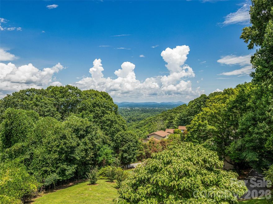Stunning year-round, panoramic views of the Blue Ridge mountains and Hendersonville! Make this your mountain getaway in the coveted Laurel Park area, minutes from bustling downtown but feeling miles away. Sip your coffee while the sun wakes the mountains or your wine while you take in spectacular sunsets, not to mention birds eye views of fireworks every 4th of July. Set above the treetops, this 2 bed/2 bath condo offers light flooded, lock and go living. The third bedroom is located in the detached second living quarters, a fully finished and conditioned daylight basement apartment. With its own entrance, living room, bedroom, full kitchen and bath, this approximately 500sf of additional space could be used as a mother in law suite, private guest accommodation, office or long term rental. Don't miss your chance to see this low maintenance condo in a great community! These units did not experience any damage from Hurricane Helene.