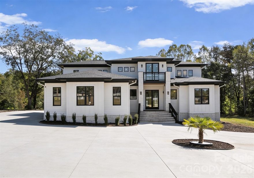 Built in 2023, this modern masterpiece sits behind a private gate on nearly 10 fully fenced acres. The home’s striking design features soaring ceilings, 8’ doors on the main-level, and a two-story living room with folding glass doors that open completely to the outdoors. The kitchen impresses with a sprawling island, beautiful quartz counters, and KitchenAid appliances. Two bedroom suites are on the main level, with the primary upstairs offering access to a huge balcony with sleek glass-metal railings. Spa-like baths feature rainhead showers and a freestanding tub. Outdoor living shines with multiple covered porches, and an oversized pergola—perfect for entertaining. Additional features include epoxy garage floors and a spacious workshop. A rare blend of design, privacy, and functionality on 9.9 serene acres just minutes from the growing I-40/I-77 corridor in Statesville.