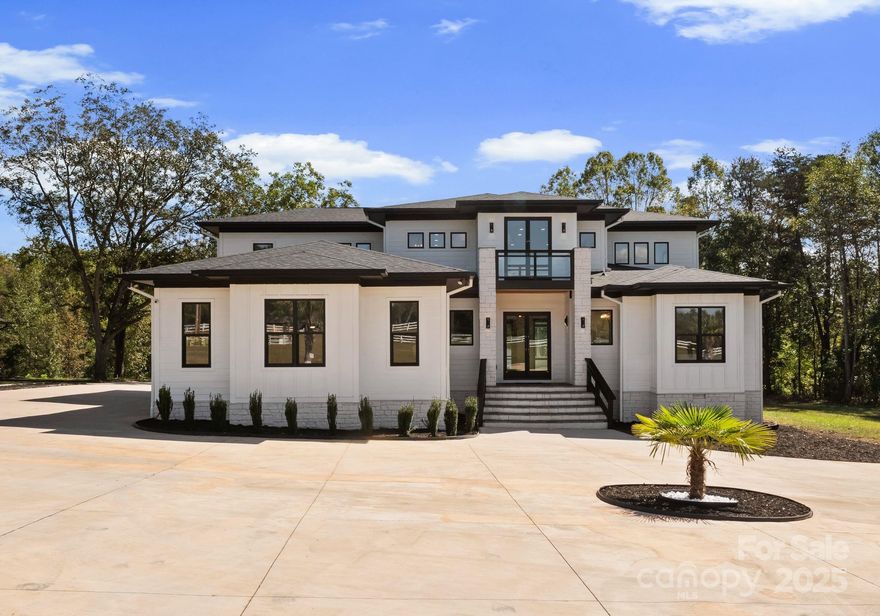 Built in 2023, this modern masterpiece sits behind a private gate on nearly 10 fully fenced acres. The home’s striking design features soaring ceilings, 8’ doors on the main-level, and a two-story living room with folding glass doors that open completely to the outdoors. The kitchen impresses with a sprawling island, beautiful quartz counters, and KitchenAid appliances. Two bedroom suites are on the main level, with the primary upstairs offering access to a huge balcony with sleek glass-metal railings. Spa-like baths feature rainhead showers and a freestanding tub. Outdoor living shines with multiple covered porches, and an oversized pergola—perfect for entertaining. Additional features include epoxy garage floors and a spacious workshop. A rare blend of design, privacy, and functionality on 9.9 serene acres just minutes from the growing I-40/I-77 corridor in Statesville.