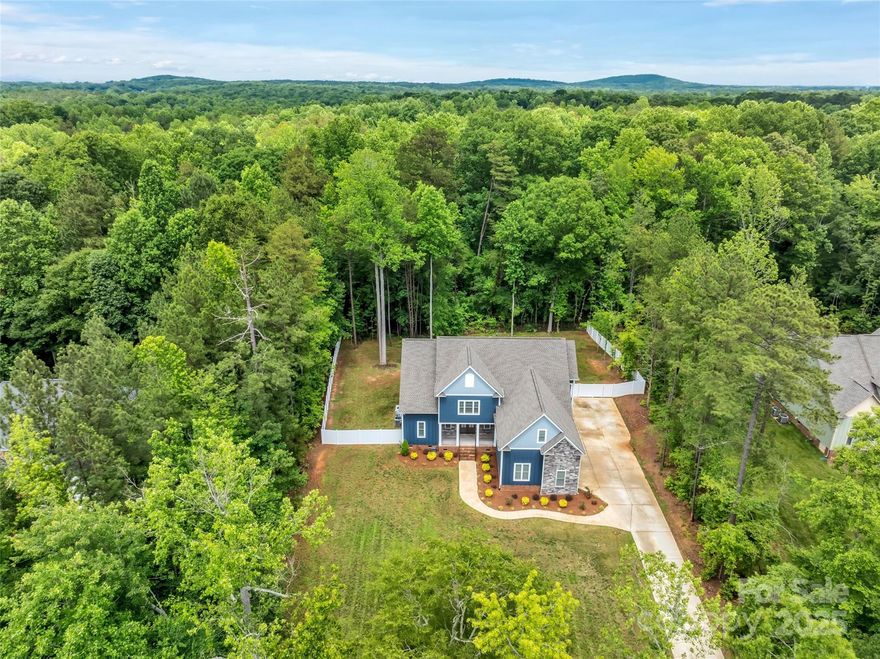 GORGEOUS CUSTOM built home in 2023 on a 1 acre Lot, Clover Schools! 3 Car Garage. Gourmet white kitchen with professional Wolf Gas Range plus wall ovens, stainless appliances, microwave drawer in island, custom cabinetry, quartz countertops.  Large kitchen pantry. Drop Zone with beautiful wood cabinetry plus laundry room. Great Room with vaulted ceiling, fireplace with beautiful tile surround & built ins. Luxury Lighting. Dining area with white shiplap. Primary Bedroom on main with custom ceiling drop lighting.  Primary Bath has soaking tub, water closet, walk in closets with built in system& beautiful tile 6 x 4 shower.  Hickory wood floors on main.  Upstairs 3 bedrooms, Jack n Jill bath. Bedroom 2 has en suite.  All have large walk in closets.  Huge bonus room with storage plus walk in storage! Plantation Shutters, security system. Front Porch, backyard Screen porch & fenced backyard. Wooded lot & private. Home Warranty Supreme Plan through Aug 2027.